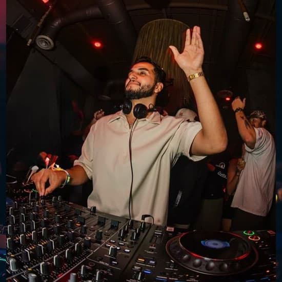 A DJ with an arm in the air at District Atlanta