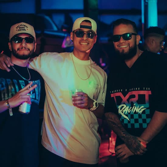 Three friends on the dance floor at a QUEMA night